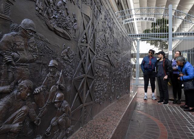 Community members gather around Ruth Asawa’s Japanese Internment Memorial statue in front of the Federal Building in downtown San José.